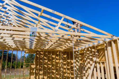Roofer carpenters works on roof at height workers nailing wood beams the roof new building...