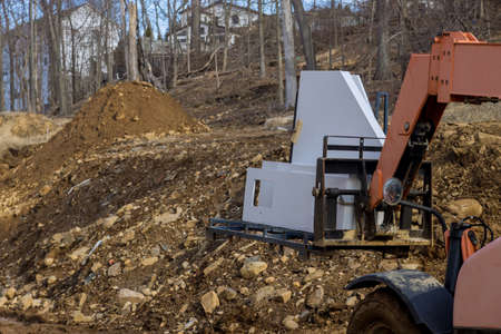 A kitchen granite being lifted by a boom truck forklift with building construction site of a new...