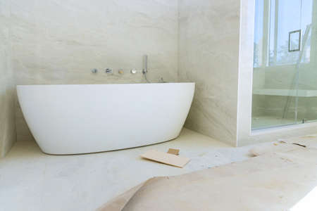 Construction work installing ceramic tile on renovation of bathroom during or renovationの写真素材