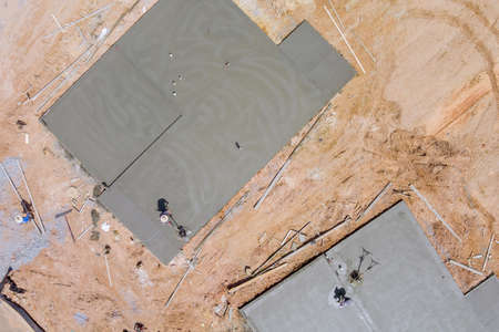 Worker labor the working polishing scrubbing with concrete cement foundation floor at house under construction siteの写真素材