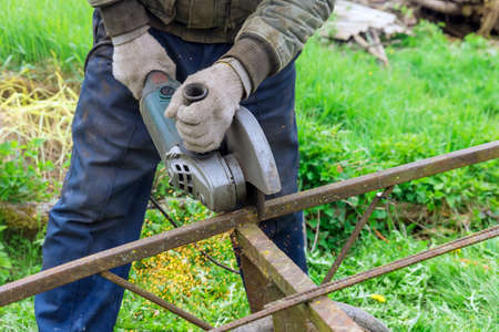 Close up on the sides fly bright sparks from the angle grinder metal sawing