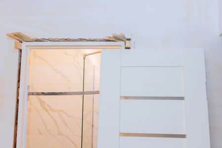 Home under reconstruction with installing door unit the door frame using a mounting foam