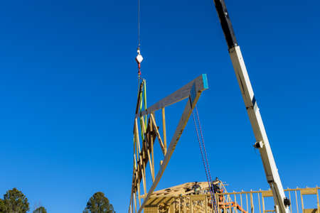 Installation construction wooden framework of crane holds roof beams frame trusses house