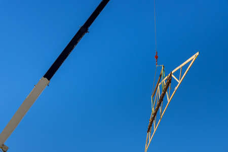 Top view of framed building residential home with crane holds wood roof trusses