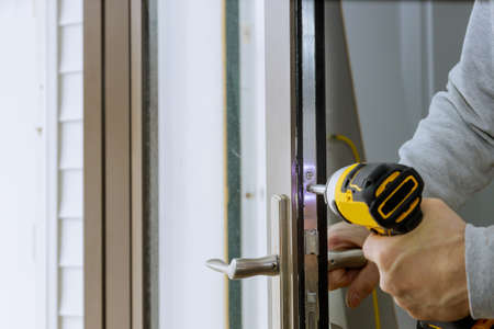 Locksmith install the door new lock in house.の写真素材