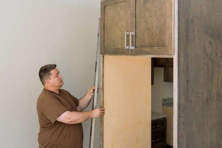 Worker hanging level the leveling new kitchen cabinets furniture set installationの写真素材