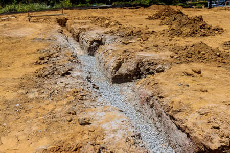 Building a new home on a under construction site involves digging a trench for a concrete foundation