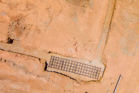 A construction site is being prepared with dug trench under a concrete foundation for a new home an...