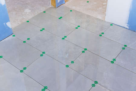 A new home is the process of construction with laying ceramic tile to flooor in the bathrooms