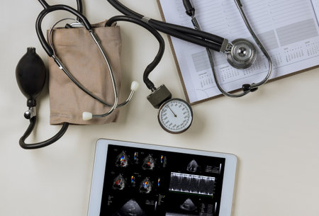 As doctor checks his results on tablet, the echocardiography ultrasound of heart examination will be analyzed in order to prescribe right treatmentの写真素材