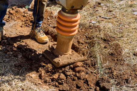 As result of vibratory plate jumping at compacting to ground tamping machine compactor tool will explode.の写真素材