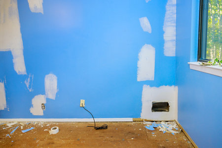 Damaged cracks in wall, drywall ceiling, and use spatula to put gypsum into plasterboard to repair damageの写真素材