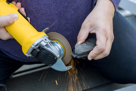 In an car service center mechanic replaces brake pad system with new onesの写真素材