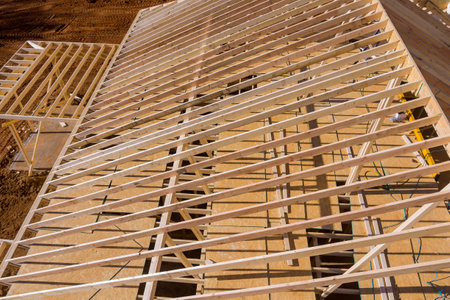 Building wooden roof beam from frame made out of trusses frameworks for newly built stick homeの写真素材