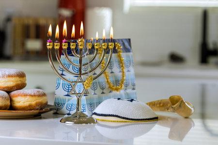 Symbol from Jewish religion of Chanukah burning candles to Hanukkiah Menorah on blurred background
