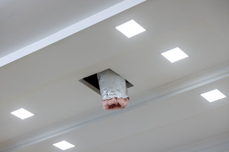 As part of renovation process ventilation and air conditioning system is being installed on ceiling of house which has already been paintedの写真素材