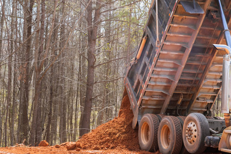 Dump truck is moving down soil leveling ground on construction siteの写真素材