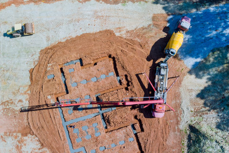 Building construction worker pouring concrete to foundation of house is using concrete pumpの写真素材
