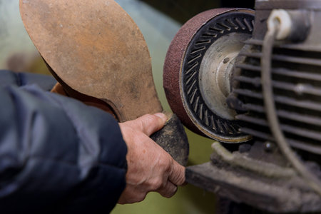 An expert who repairs shoes in his workshop taking care of shoes workshopの写真素材
