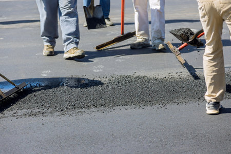 Construction worker laying new asphalt roads as part process of asphaltingの写真素材