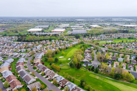 On an aerial panorama view of small American town, there is residential district with houses and roads with spring trees in landscape.の写真素材