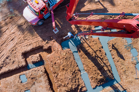 During construction of pour concrete strip foundations using an automatic pump to direct cement concreteの写真素材