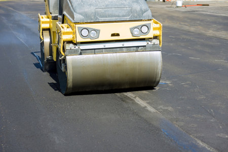Asphalt paver machine on road repair site road renewal process, construction working