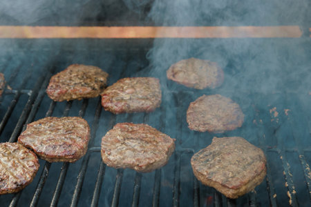 On bbq fire flame grill prepared cooked grilled beef meat barbecue burgers for hamburgersの写真素材