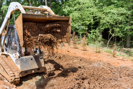 Planning work site on improvement of tractor prepares courtyard territory for construction