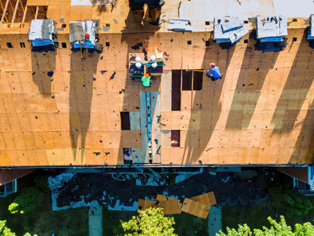 Roof of an apartment building was repaired by installing new shingles and replacing old plywoodの写真素材