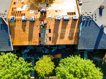 During repair roof an apartment building were installed new shingles and plywood was replace old onesの写真素材