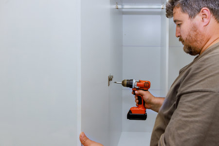 Carpenter was assembling furniture closet cabinets that needed to be installed on wall.の写真素材