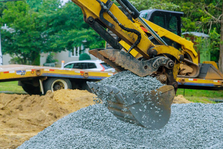 Preparing basis to new road with laying filled crushed stone gravel using tractor