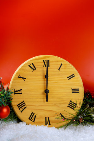 An ornamental fir tree branch with festive balls, retro style clock on red background with wishes for Happy New Yearの写真素材