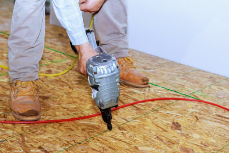 New home installation wooden plywood using an air nail gunの写真素材