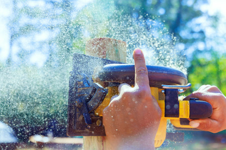 Using an electric saw to cut wooden post for fence