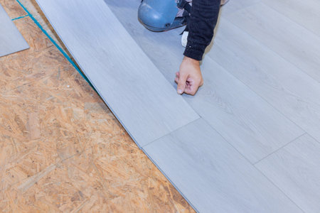 Worker installs vinyl laminate flooring in new residenceの写真素材