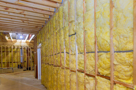 Thermal fiberglass insulation mineral rock wool installation to wall at new construction homeの写真素材