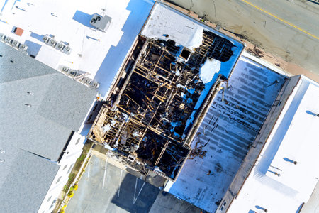 After fire, burned wooden house had its roof destroyedの写真素材