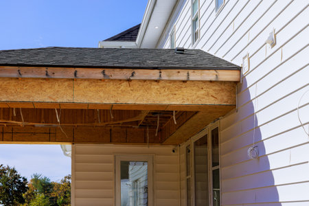 Corner porch of house with eaves beams planks wooden rafters is under constructionの写真素材