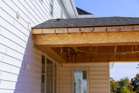 Under construction is corner porch of house with eaves beams, planks, wooden raftersの写真素材
