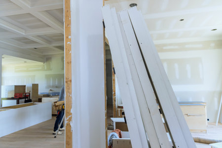Plastering drywall in preparation for painting newly constructed houseの写真素材