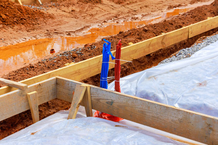 Ground is covered with first layer of insulation waterproofing prior to pouring foundation of house