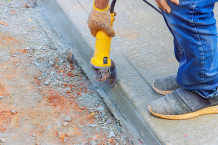 Cutting concrete foundation after pouring with grinder using cutting machinesの写真素材