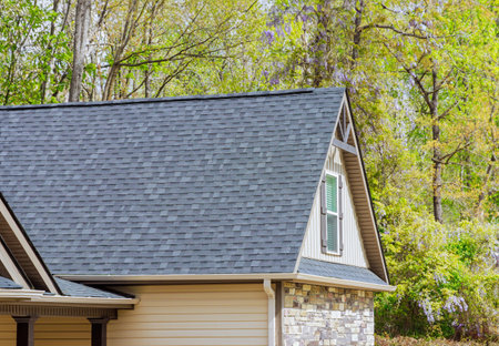 On newly constructed home, overlapping asphalt shingles are seen on roofの写真素材