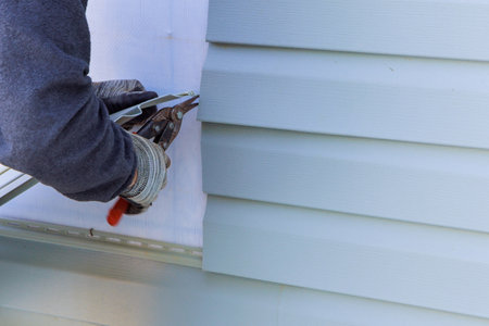During exterior house renovations, damaged plastic siding is replacedの写真素材
