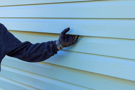 During exterior house remodel reconstruction of house, damaged plastic siding is replacedの写真素材