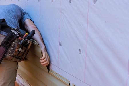 Installing vinyl PVC siding during construction on new home facadeの写真素材