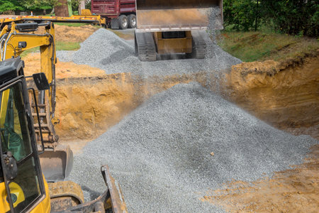 Construction site irregularities are filled with granite rubble base prior to concrete foundation being builtの写真素材