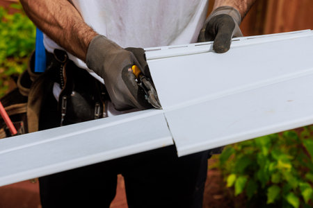 Facade of house is constructed by cutting vinyl siding panels to desired size before they are installedの写真素材